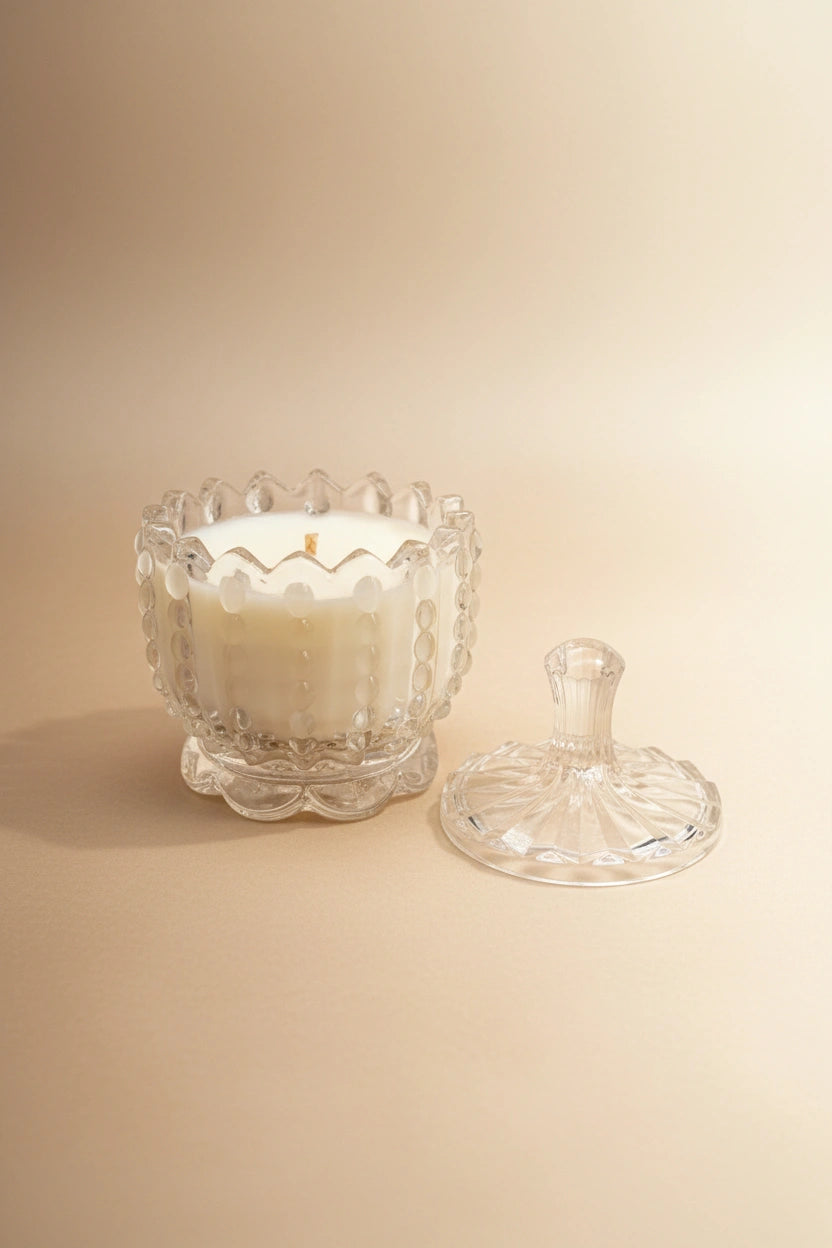 Candela artigianale in cera di soia in contenitore di vetro trasparente con coperchio sfondo beige neutro