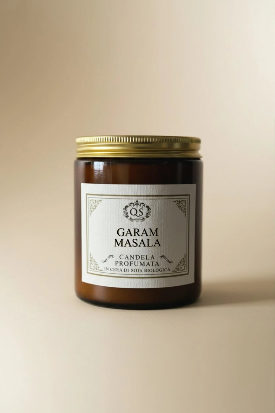 Candela soia Garam Masala in vetro ambrato con tappo dorato su sfondo beige
