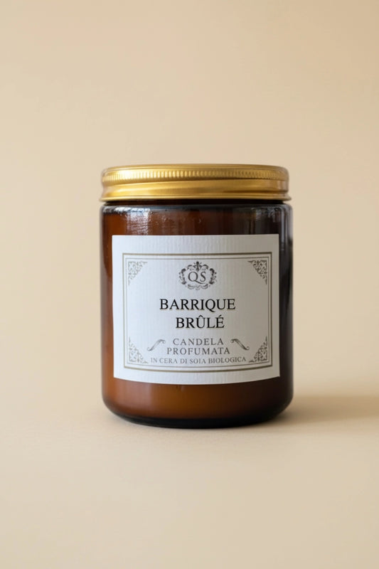 Candela profumata Barrique Brûlé in vetro ambrato con tappo dorato su sfondo beige