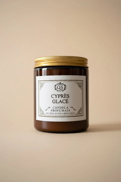 Candela profumata Cyprès Glacé in vetro ambrato con tappo dorato su sfondo beige