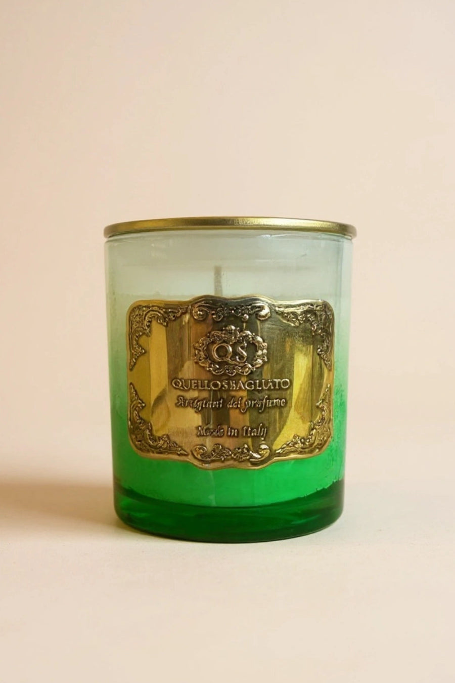Candela soia Melograno di Afrodite luxury Quello Sbagliato in vetro verde con etichetta metallica dorata su sfondo beige