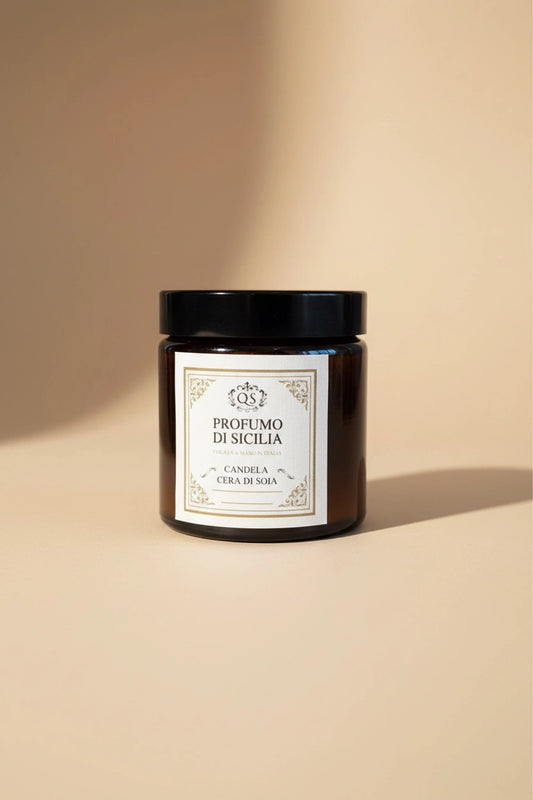Candela soia Profumo di Sicilia Quello Sbagliato in vetro scuro con etichetta classica su sfondo beige