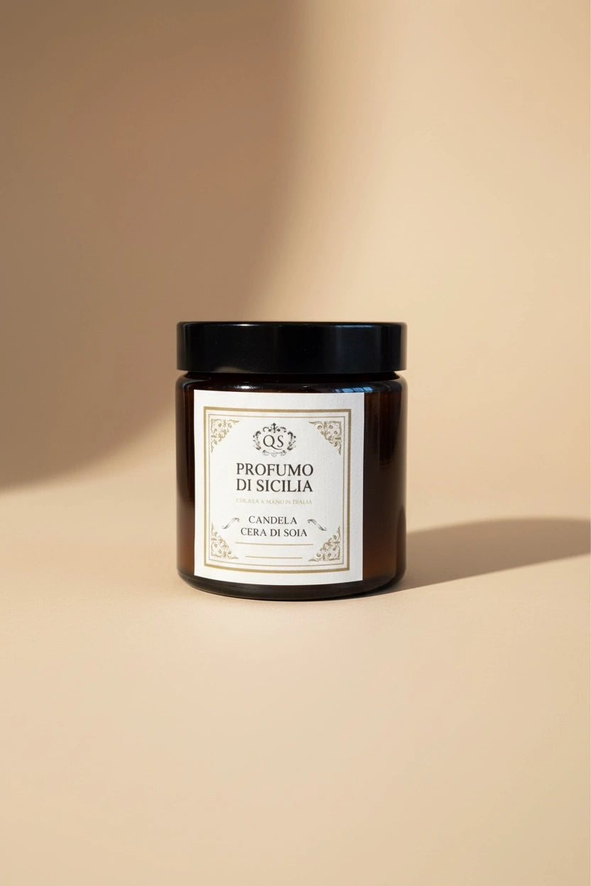 Candela soia Profumo di Sicilia Quello Sbagliato in vetro scuro con etichetta classica su sfondo beige